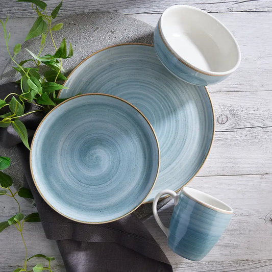 Vajilla Corona Caoba Azul: platos, bolos y mugs en azul con borde marrón.