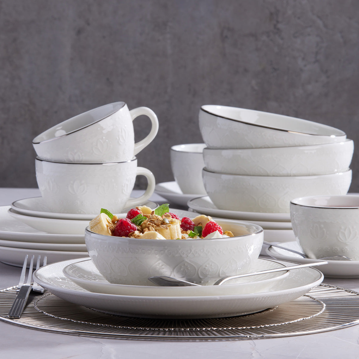 Vajilla Harmony Corona 20 piezas: loza de alta calidad con relieve floral y filo plateados.
